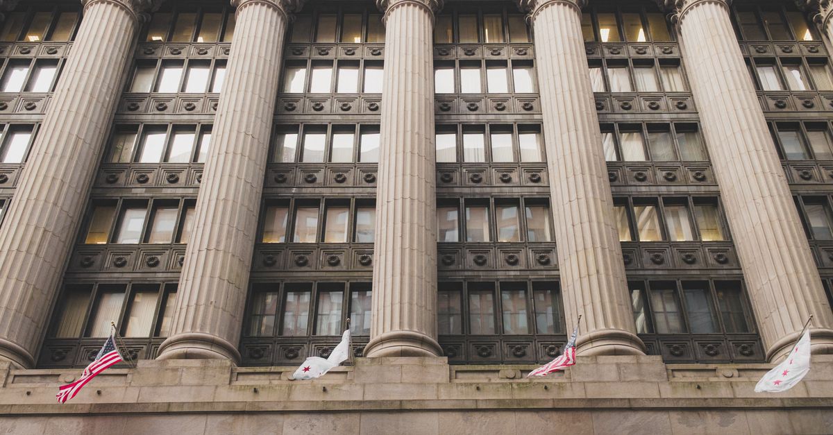 Elegant neoclassical facade with columns and flags in downtown Chicago.