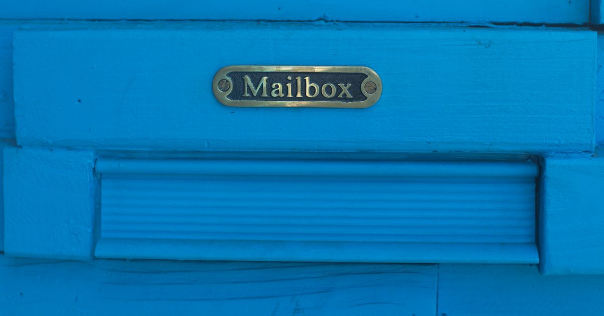 Close-up of a vibrant blue mailbox with decorative metal accents.