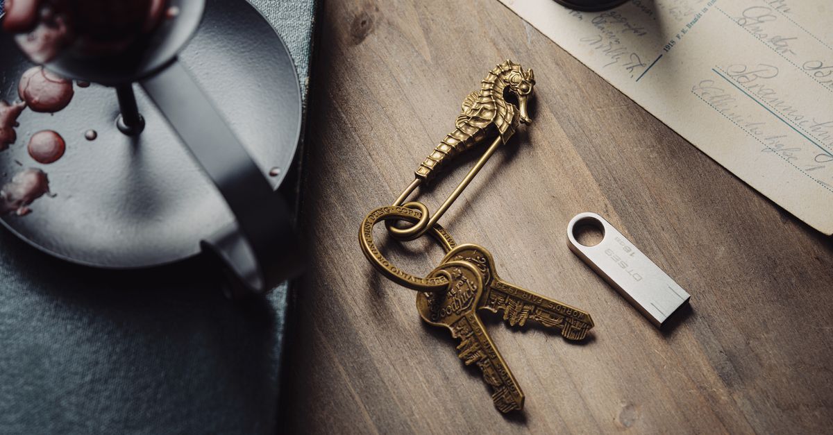 Artistic shot of a vintage seahorse keyring with keys on a wooden table, alongside candle and letter.