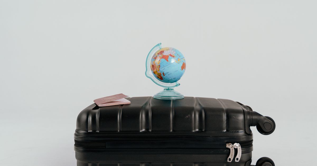A globe placed on a black suitcase symbolizing global travel and adventure.